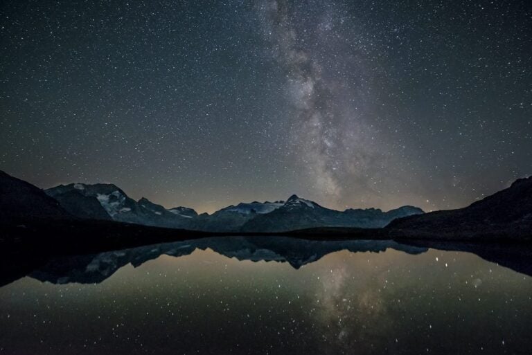 Milky Way reflected in a lake with mountains